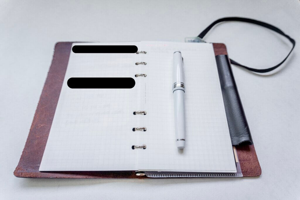 プロッター バイブルサイズを開いた状態。風光リフィルと白い万年筆が置かれた筆記シーンの写真。