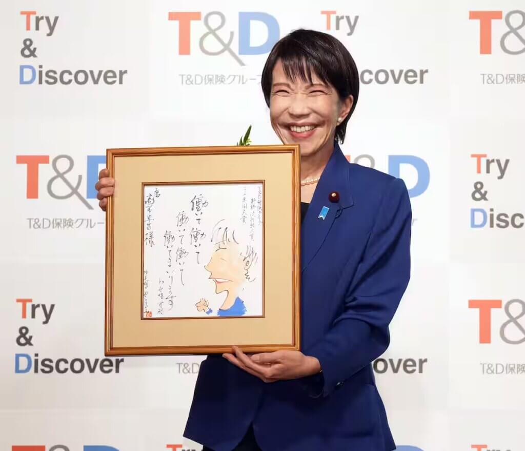 新語・流行語大賞 2025受賞式典で額に入った言葉を掲げる高市首相