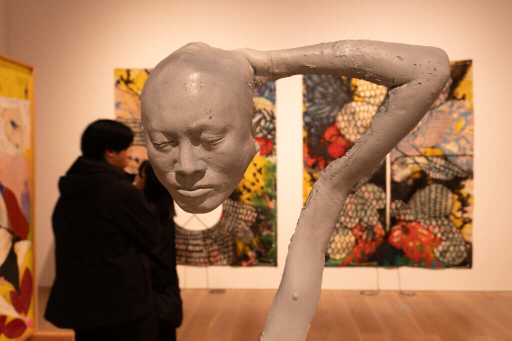 顔と脚が直結した彫刻作品を斜めから捉えた展示風景