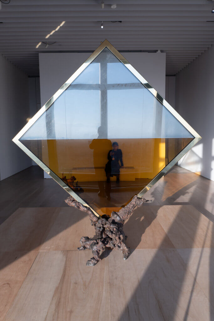 ブランデー色の液体が注がれた菱形ガラス作品「MITTAG（正午）」のクローズアップ